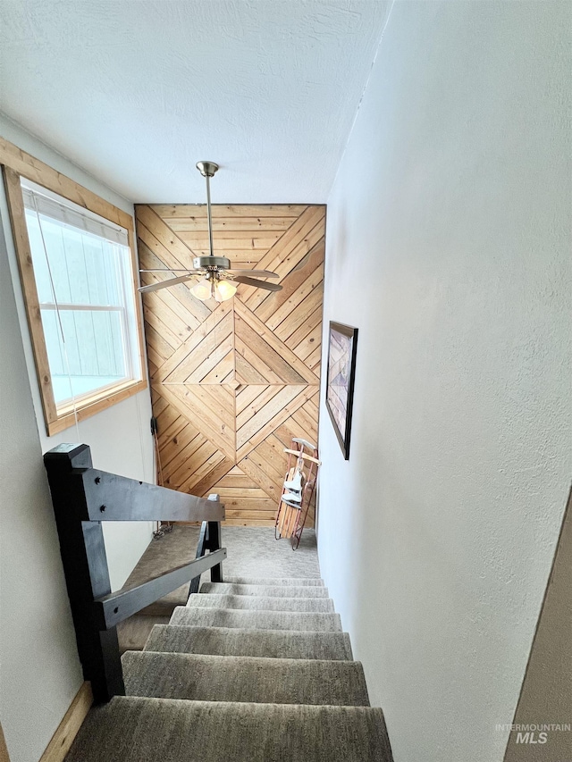 301 N Mission St Unit C3, Mccall, ID 83638 - stairs with carpet flooring, wooden walls, and a ceiling fan