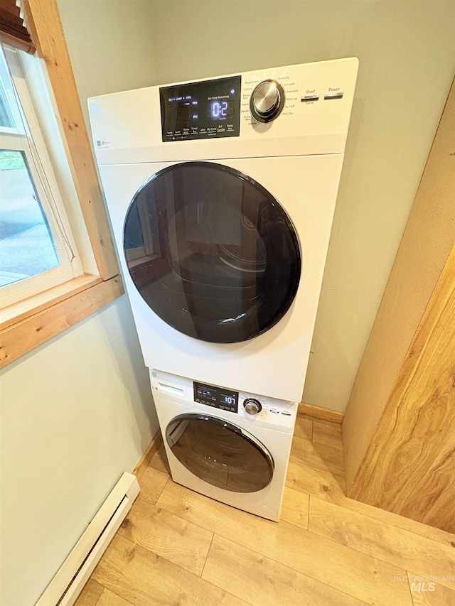 301 N Mission St Unit C3, Mccall, ID 83638 - laundry room with stacked washer and clothes dryer, baseboard heating, and wood finished floors