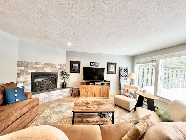 301 N Mission St Unit C3, Mccall, ID 83638 - living room with light wood-type flooring, a textured ceiling, a glass covered fireplace, and recessed lighting