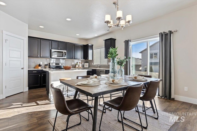 dining room with dark hardwood / wood-style flooring and an inviting chandelier