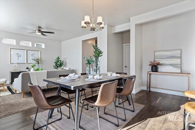 dining room featuring dark hardwood / wood-style flooring and ceiling fan with notable chandelier