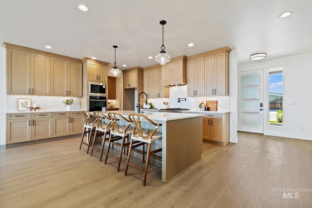 7760 W Flathead Lake St, Eagle, ID 83616 - kitchen featuring appliances with stainless steel finishes, recessed lighting, light countertops, wall chimney exhaust hood, and a kitchen island with sink