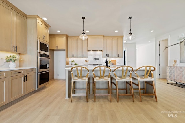 7760 W Flathead Lake St, Eagle, ID 83616 - kitchen with light wood-style floors, recessed lighting, light countertops, a breakfast bar area, and built in microwave