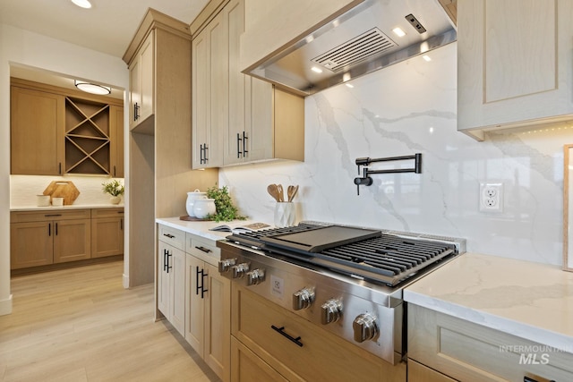 7760 W Flathead Lake St, Eagle, ID 83616 - kitchen featuring range hood, stainless steel gas cooktop, backsplash, light stone countertops, and light wood-style flooring
