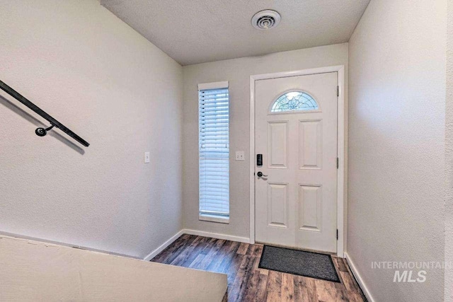 foyer entrance featuring dark wood-type flooring and a textured ceiling