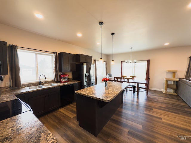 kitchen featuring dark hardwood / wood-style floors, black dishwasher, sink, a center island, and stainless steel refrigerator with ice dispenser