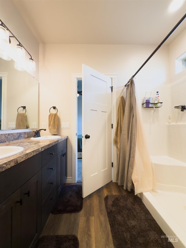 bathroom featuring hardwood / wood-style flooring, vanity, and walk in shower