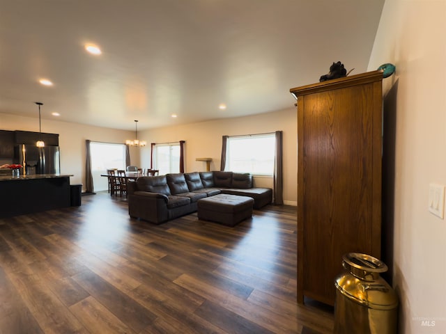 living room with a notable chandelier and dark hardwood / wood-style floors