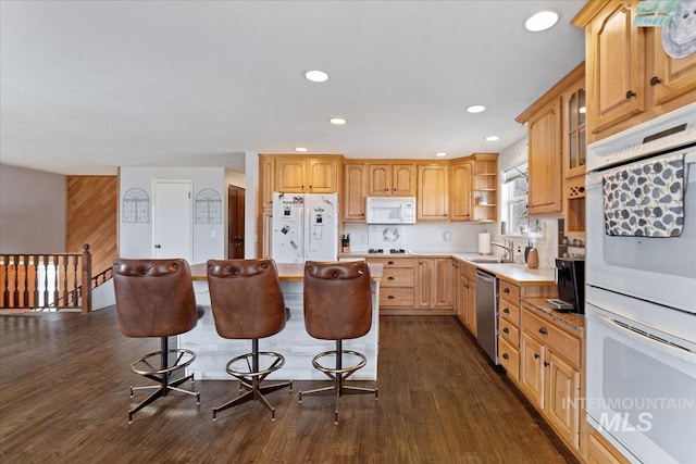 kitchen featuring white appliances, dark wood-type flooring, a kitchen breakfast bar, light countertops, and open shelves