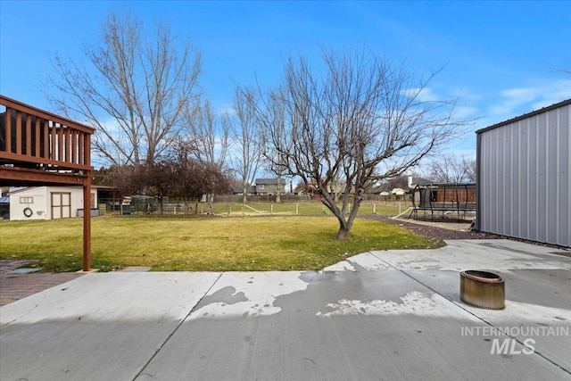 view of yard with fence, an outdoor structure, and a patio