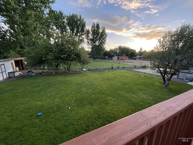 yard at dusk featuring fence