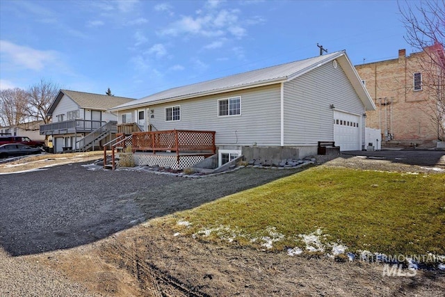 exterior space featuring a front yard, a garage, and a wooden deck