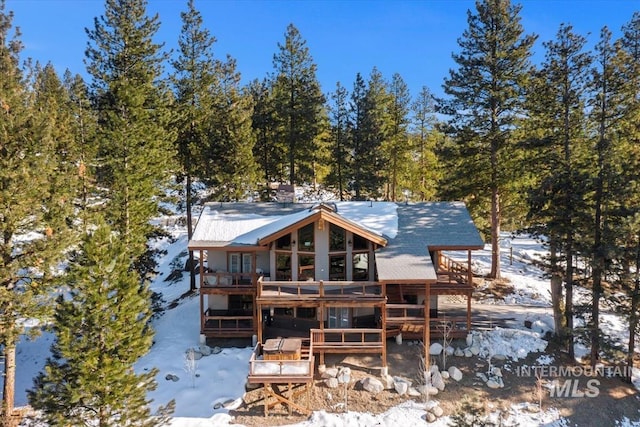 snow covered property with a deck