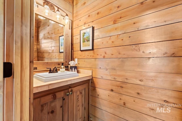 bathroom with vanity and wooden walls