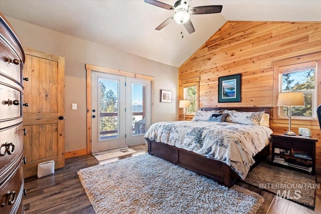 bedroom with ceiling fan, access to exterior, wooden walls, dark hardwood / wood-style floors, and vaulted ceiling