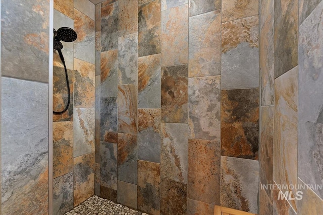 interior details featuring a tile shower