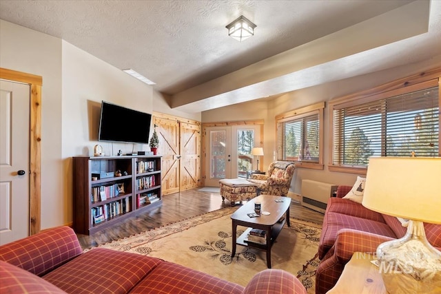 living room featuring wood-type flooring and a textured ceiling