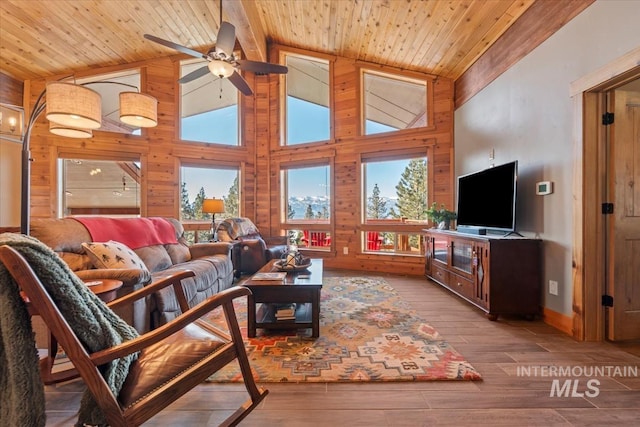 living room with wood ceiling, high vaulted ceiling, light wood-type flooring, and a wealth of natural light