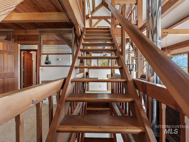 staircase featuring beam ceiling, carpet floors, and wood ceiling