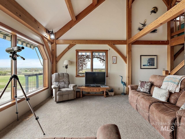 living room featuring plenty of natural light, light carpet, and vaulted ceiling with beams