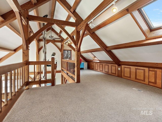 additional living space with light carpet, ceiling fan, and vaulted ceiling with skylight