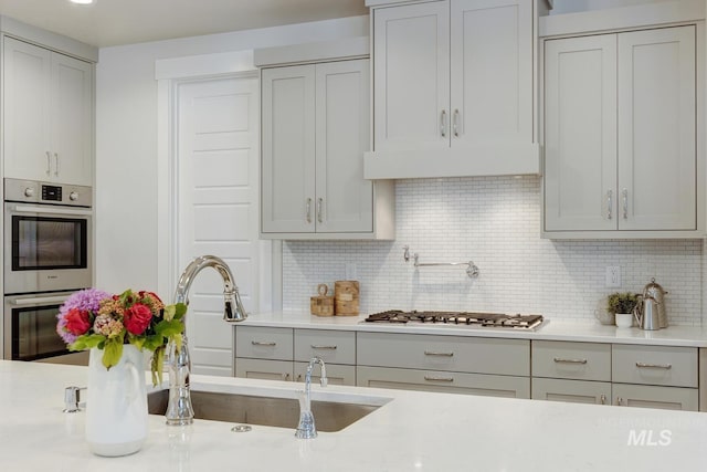 12039 N 19th Ave, Boise, ID 83714 - kitchen featuring gas stovetop, double oven, backsplash, and gray cabinets