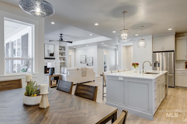 12039 N 19th Ave, Boise, ID 83714 - kitchen with stainless steel refrigerator with ice dispenser, a kitchen island with sink, light countertops, recessed lighting, and hanging light fixtures