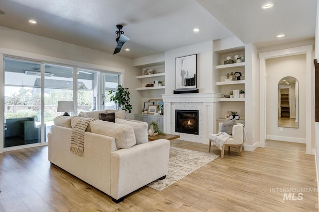 12039 N 19th Ave, Boise, ID 83714 - living room featuring a premium fireplace, light wood-style floors, built in shelves, and recessed lighting