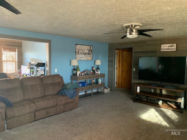 carpeted living room featuring ceiling fan and a textured ceiling