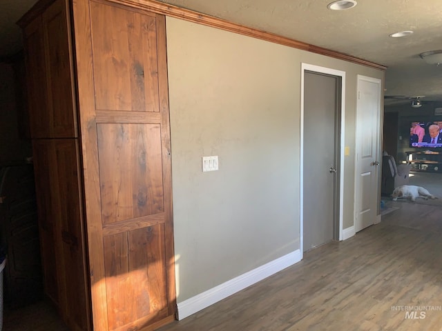 hall with hardwood / wood-style flooring and crown molding