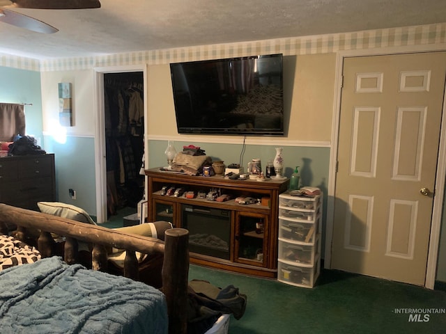 bedroom featuring ceiling fan, carpet flooring, and a walk in closet