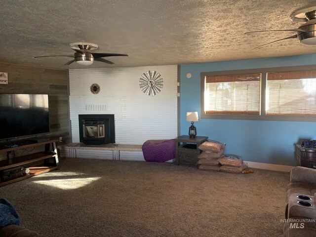 carpeted living room featuring ceiling fan, wooden walls, and a textured ceiling