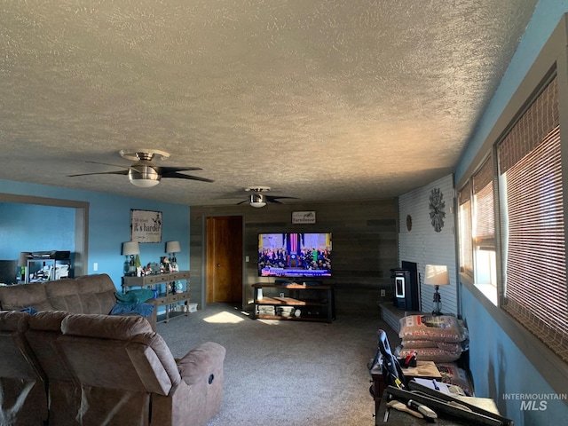 carpeted living room with ceiling fan and a textured ceiling