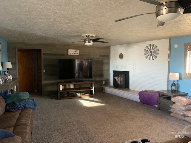 living room featuring ceiling fan, a textured ceiling, and wood walls