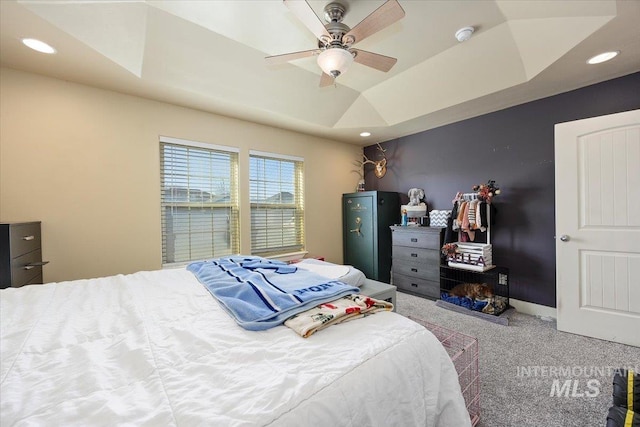 carpeted bedroom featuring baseboards, ceiling fan, a tray ceiling, and recessed lighting