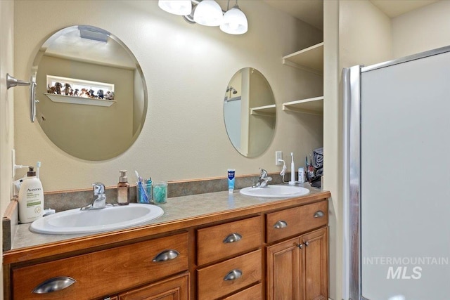 full bathroom with double vanity, an enclosed shower, and a sink