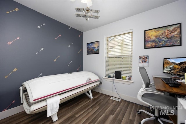 bedroom with visible vents, baseboards, and wood finished floors