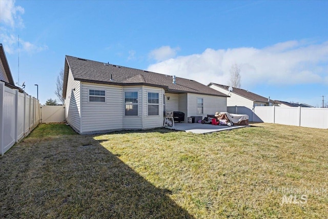 back of property with a yard, a patio area, and a fenced backyard