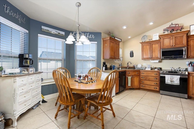 kitchen with brown cabinets, lofted ceiling, appliances with stainless steel finishes, light tile patterned flooring, and a sink