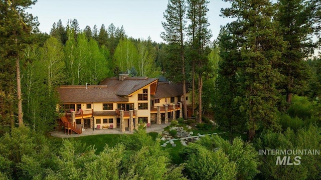 3872 Brookside Dr, New Meadows, ID 83654 - rear view of property with stairs, a deck, a wooded view, and a patio area