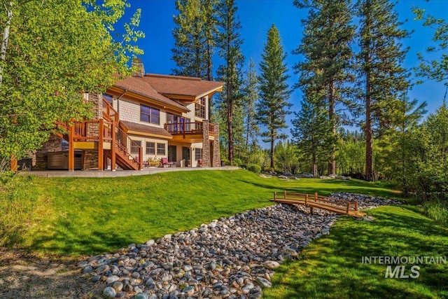 3872 Brookside Dr, New Meadows, ID 83654 - back of property featuring stairway, a wooden deck, a patio area, a lawn, and a chimney