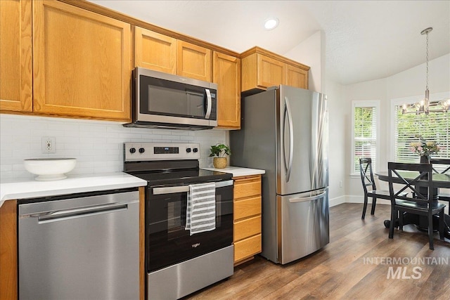 4112 W Cherrytree Ct, Meridian, ID 83642 - kitchen with stainless steel appliances, light countertops, tasteful backsplash, dark wood finished floors, and vaulted ceiling