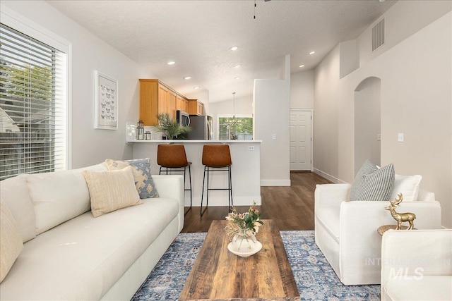 4112 W Cherrytree Ct, Meridian, ID 83642 - living room featuring dark wood-style flooring, recessed lighting, a textured ceiling, baseboards, and lofted ceiling