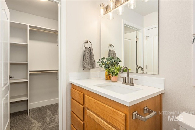 4112 W Cherrytree Ct, Meridian, ID 83642 - bathroom with vanity, a walk in closet, and toilet
