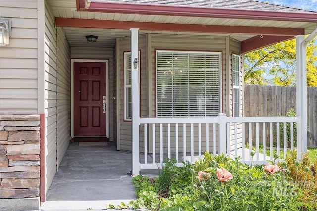 4112 W Cherrytree Ct, Meridian, ID 83642 - property entrance featuring a shingled roof, covered porch, and fence