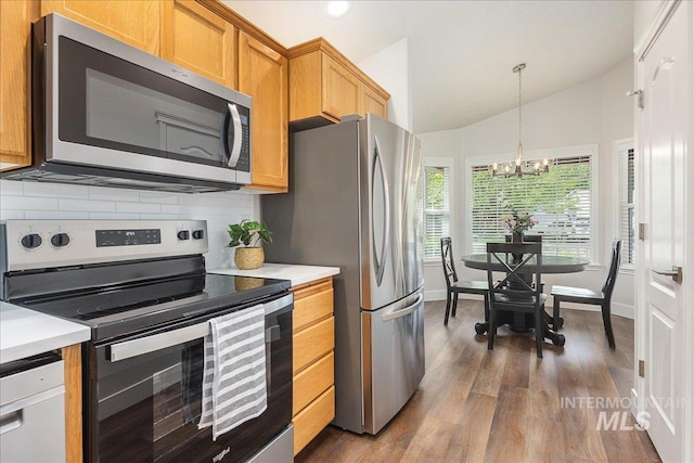 4112 W Cherrytree Ct, Meridian, ID 83642 - kitchen with appliances with stainless steel finishes, dark wood finished floors, tasteful backsplash, a chandelier, and light countertops