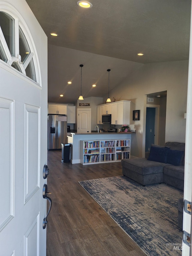 living room featuring vaulted ceiling, dark wood finished floors, visible vents, and recessed lighting