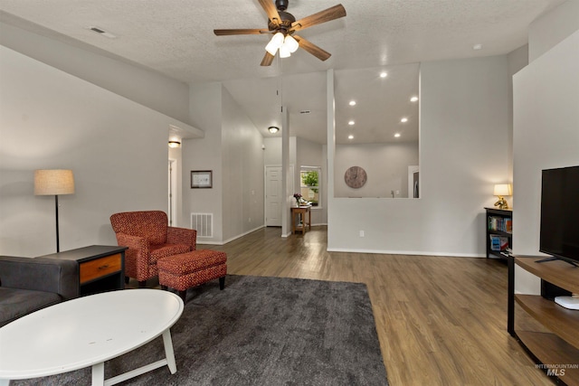 3422 Vistapark Dr, Caldwell, ID 83605 - living room featuring wood finished floors, a ceiling fan, a textured ceiling, baseboards, and vaulted ceiling