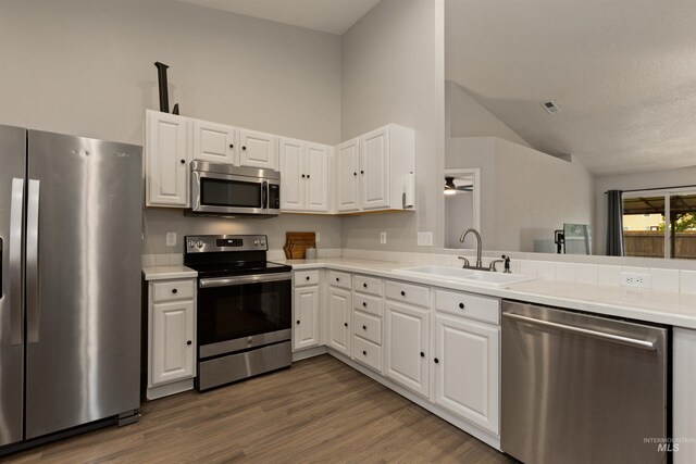 3422 Vistapark Dr, Caldwell, ID 83605 - kitchen featuring stainless steel appliances, a sink, lofted ceiling, white cabinetry, and light countertops