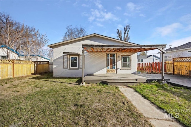 rear view of property with a fenced backyard, a pergola, a deck, and a lawn